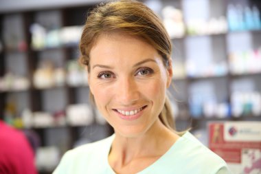 Smiling pharmacist woman in drugstore clipart