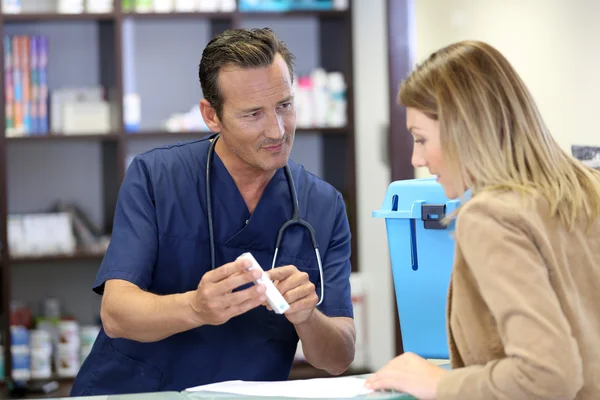 Veterinarian giving medical prescription to client — Stock Photo, Image