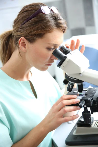 Doctor looking through microscope — Stock Photo, Image