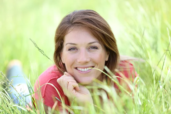 Donna sorridente che posa nel campo di campagna — Foto Stock