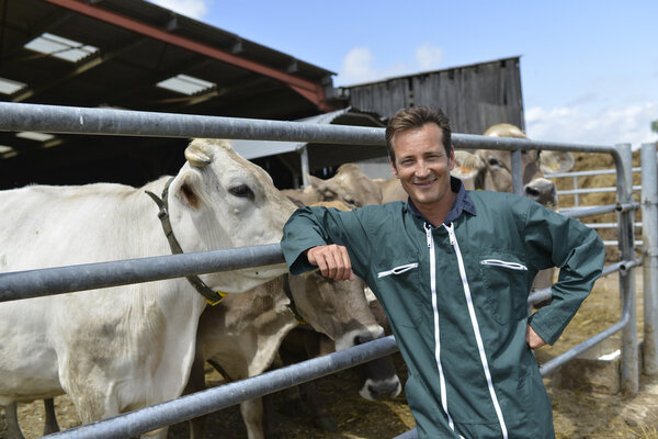 Smiling farmer standing by barn