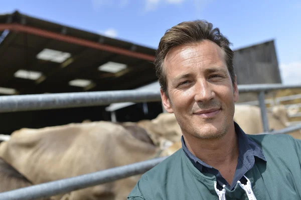 Smiling farmer standing by barn — Stock Photo, Image