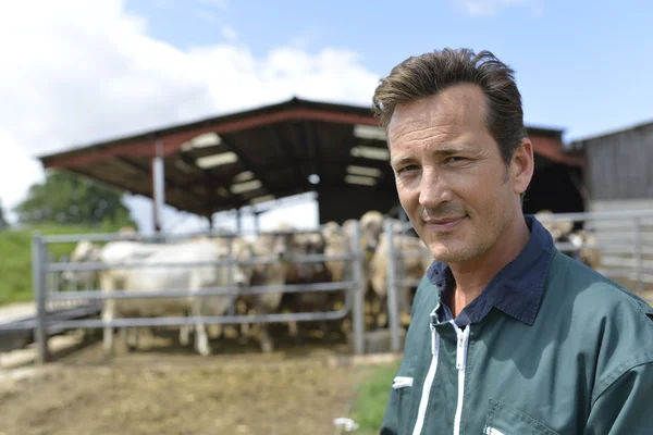 Fermier souriant debout près de la grange — Photo