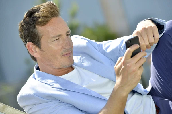 Man relaxing and using smartphone — Stock Photo, Image
