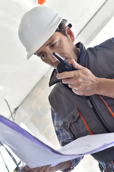 Construction worker checking blueprint — Stock Photo, Image