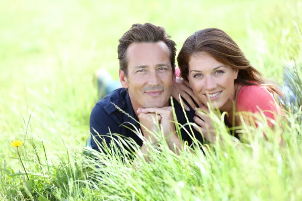 Couple laying in country field Stock Picture