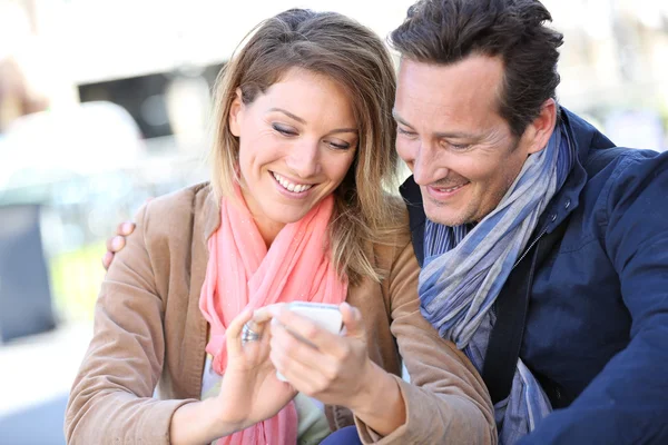 Paar in de stad gebruikend smartphone — Stockfoto