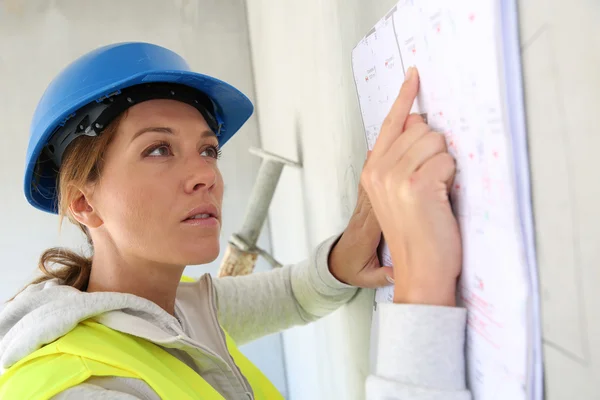 Woman architect reading construction plan — Stock Photo, Image