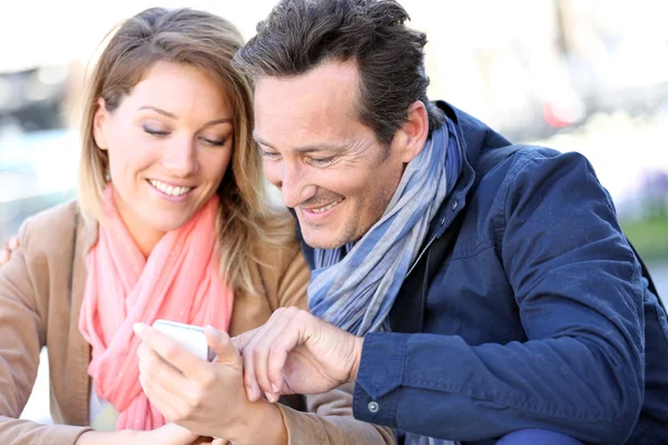 Paar in de stad gebruikend smartphone — Stockfoto