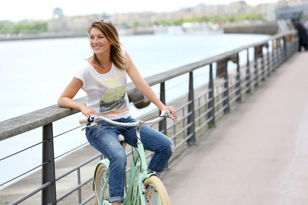 Mulher com bicicleta relaxante pelo rio — Fotografia de Stock