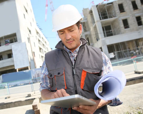 Entrepreneur on building site using tablet — Stock Photo, Image