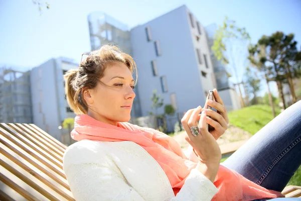 Woman relaxing in park near city — Stock Photo, Image