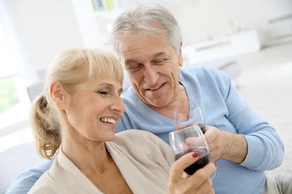 Starší pár, pití červeného vína — Stock fotografie