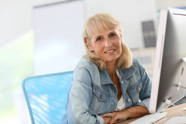 Woman working on desktop computer — Stock Photo, Image