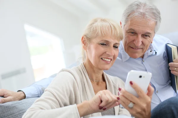 Pareja en casa usando smartphone — Foto de Stock