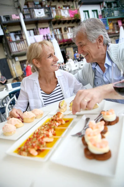 Pareja comiendo español fingerfood — Foto de Stock