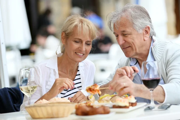 Pareja comiendo español fingerfood —  Fotos de Stock