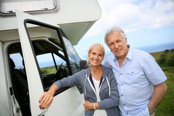 Couple standing in front of camping car — Stock Photo, Image
