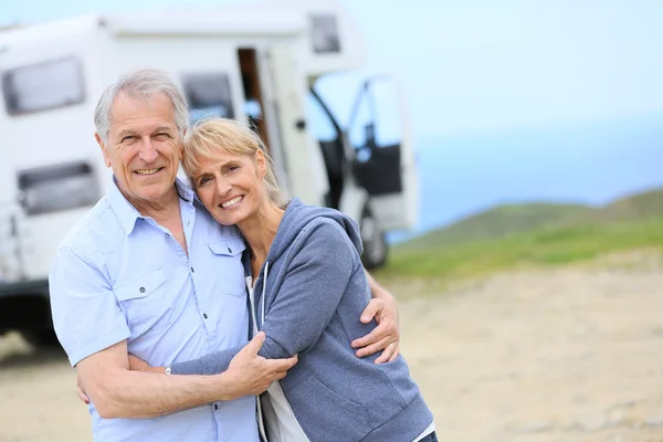 Couple standing by camper on road stop — Stock Photo, Image