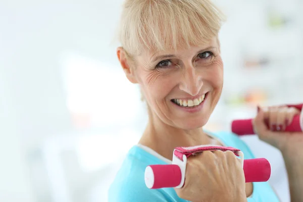 Senior woman lifting dumbbells Stock Photo