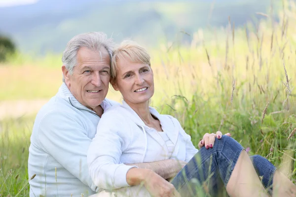 Couple relaxing in wild grass field Stock Photo