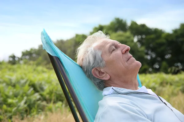 Senior mand afslappende i camping stol Stock-foto
