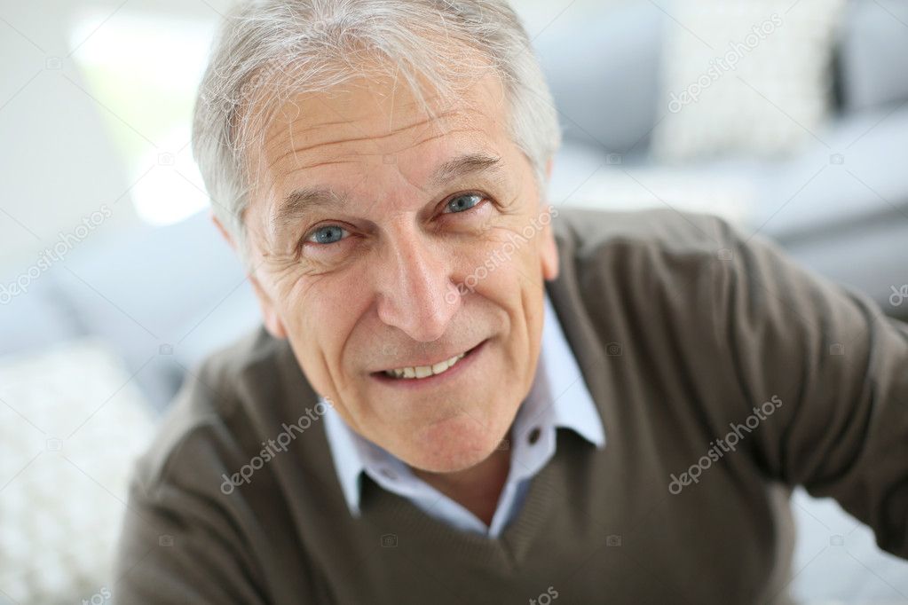 Smiling senior man sitting on sofa