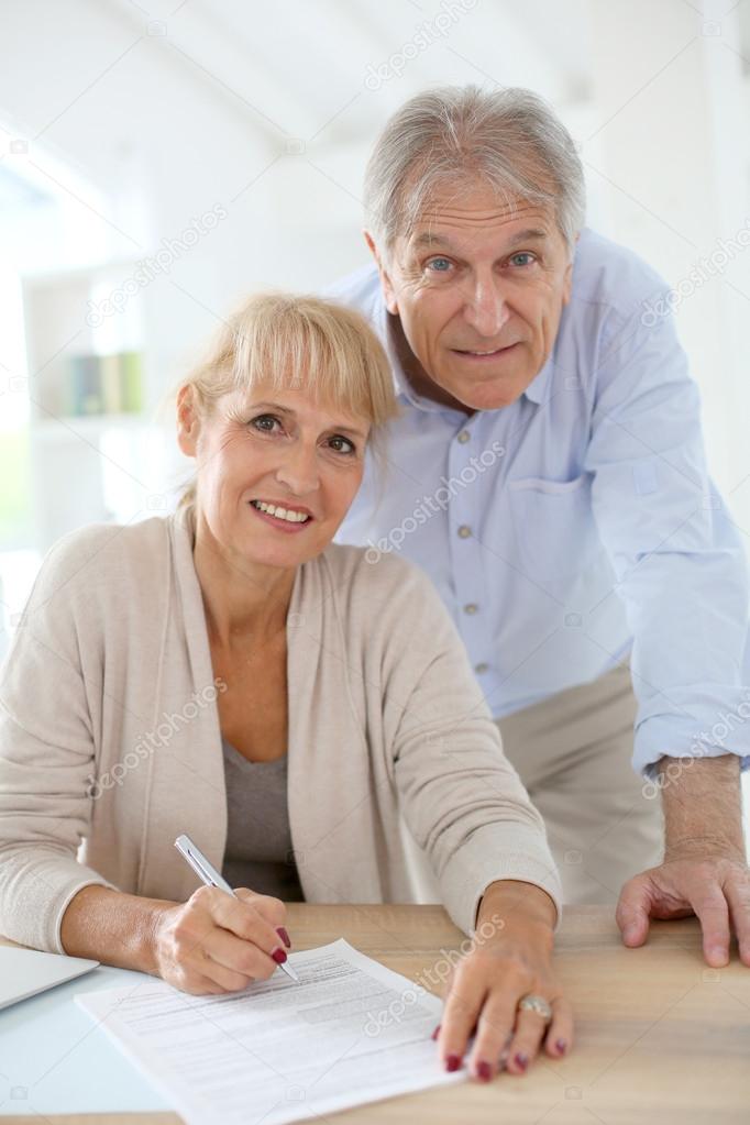 Couple at home filling pension paper