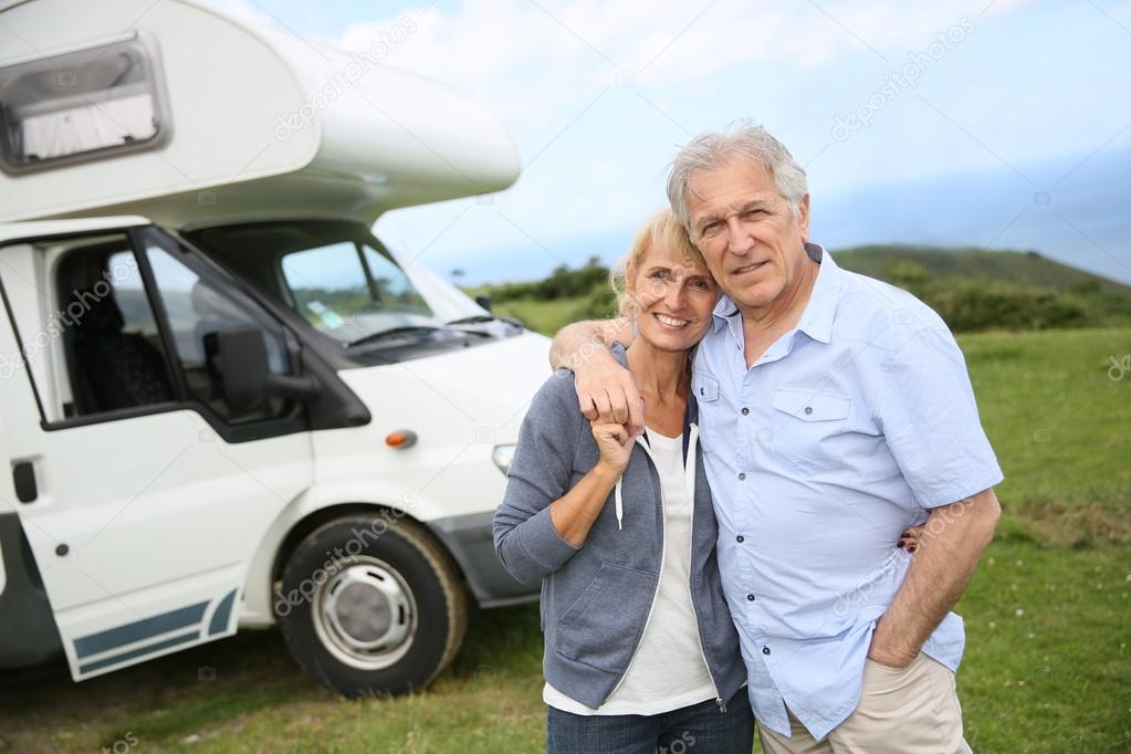 Couple standing in front of camping car