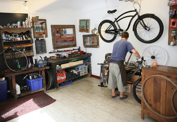 Hombre trabajando en tienda de bicicletas — Foto de Stock
