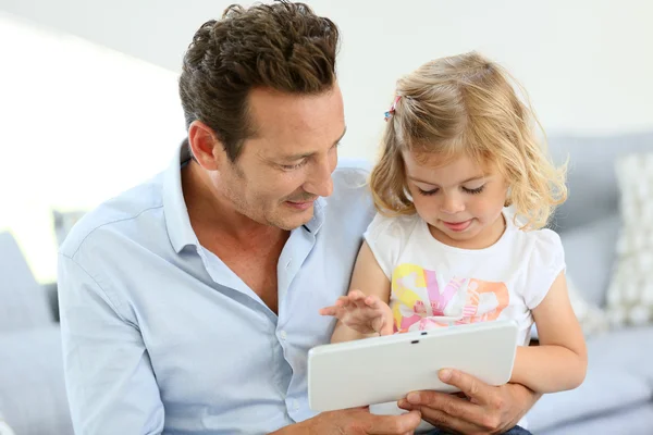 Отец и дочь играют с планшетом — стоковое фото