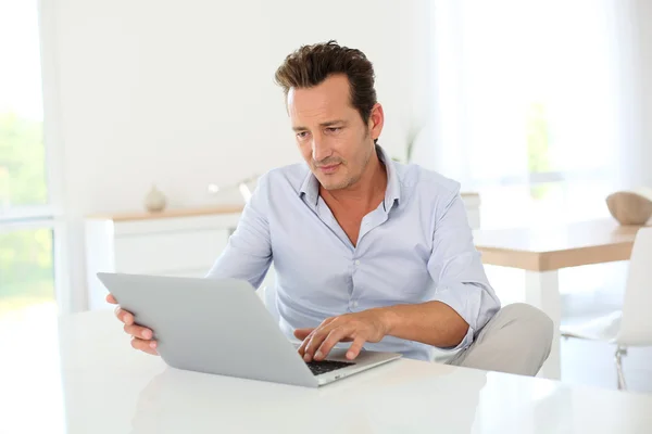 Homem usando laptop em casa — Fotografia de Stock