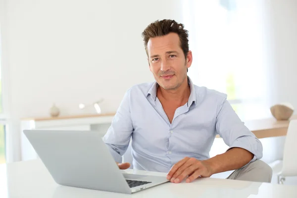 Homem usando laptop em casa — Fotografia de Stock