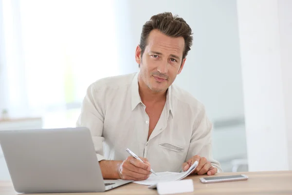 Homme souriant travaillant à la maison — Photo