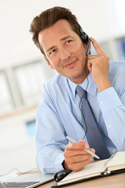 Zakenman praten over telefoon met headset — Stockfoto