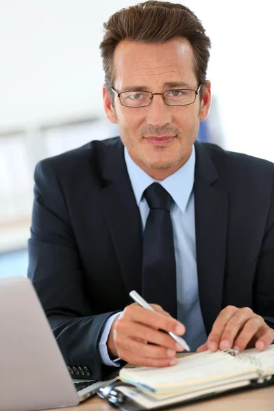 Businessman in office working on laptop — Stock Photo, Image