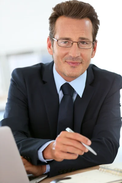 Executivo com óculos trabalhando no laptop — Fotografia de Stock
