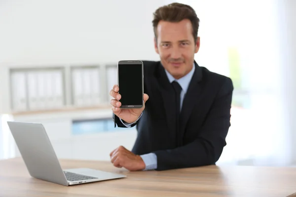 Geschäftsmann zeigt Smartphone — Stockfoto