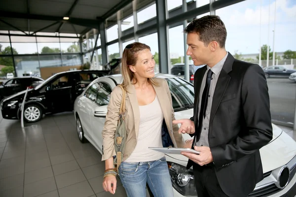 Distribuidor de coches mostrando vehículo a mujer — Foto de Stock