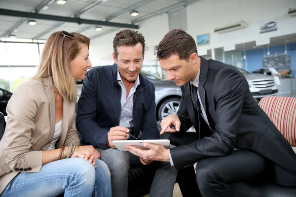 Couple signing car purchase order — Stock Photo, Image