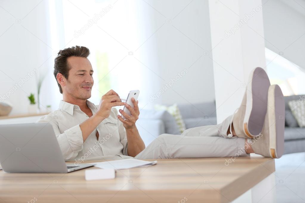 Relaxed man using smartphone