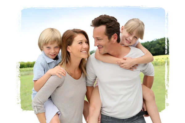 Parents giving piggyback ride to kids — Stock Photo, Image