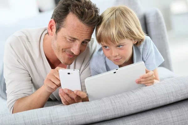 Отец и сын с планшетом и смартфоном — стоковое фото