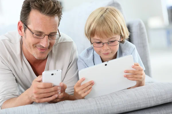 Far och son med tablett och smartphone — Stockfoto