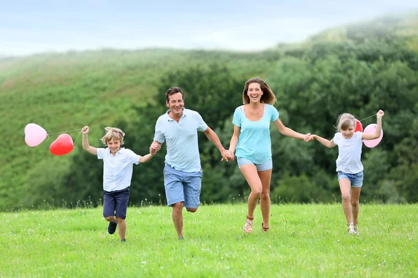 Família correndo no campo — Fotografia de Stock