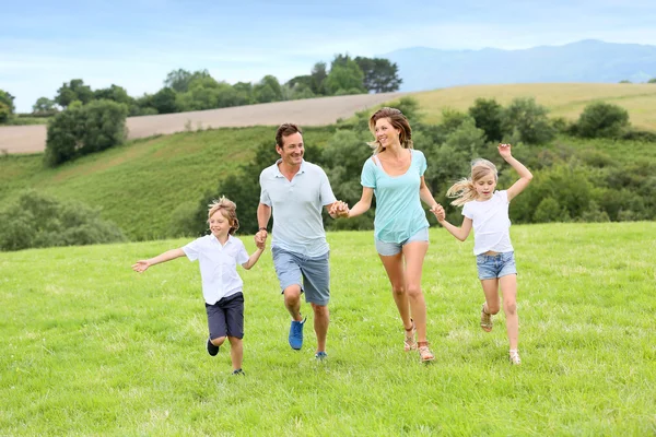 Happy family running in countryside — Stock Photo, Image