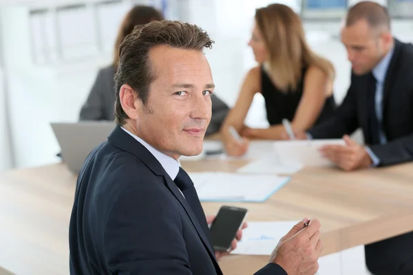 Homem corporativo sentado na mesa de reunião — Fotografia de Stock