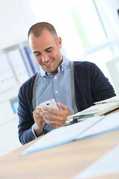 Trabalhador de escritório usando smartphone no trabalho — Fotografia de Stock