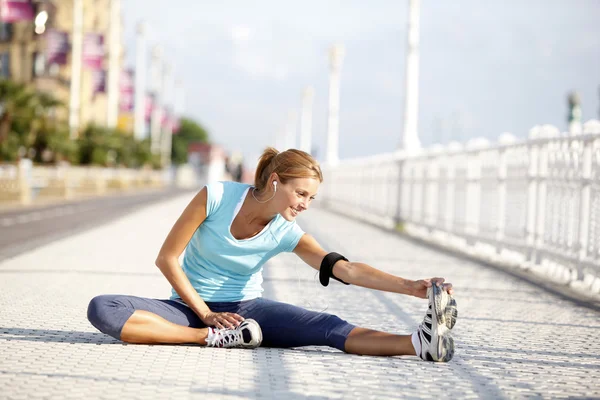 Jogger stretching after exercising in street — Stock Photo, Image