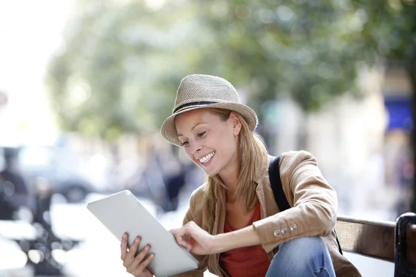 Girl using tablet sitting on bench — Stock Photo, Image